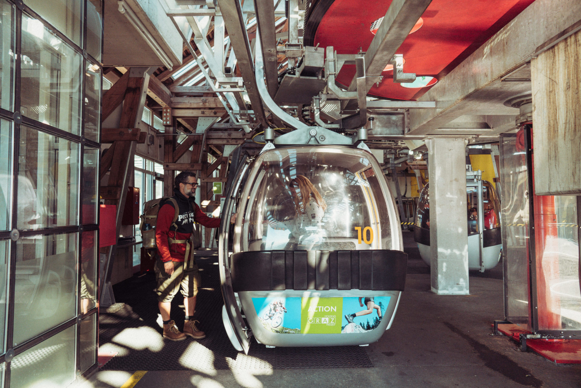 Wanderer besteigt eine Gondel der Schöckl Seilbahn in der Talstation