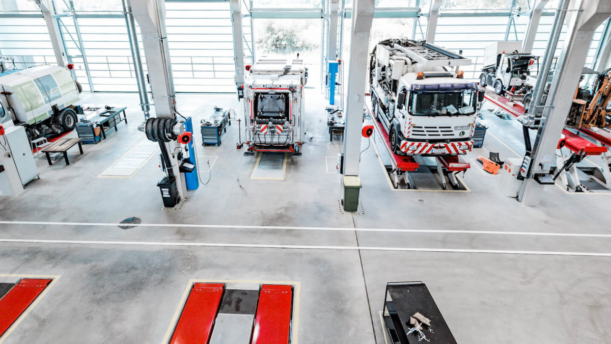Innenansicht der Holding Graz Kommunalwerkstätte mit Fahrzeugen, die repariert werden sollen.