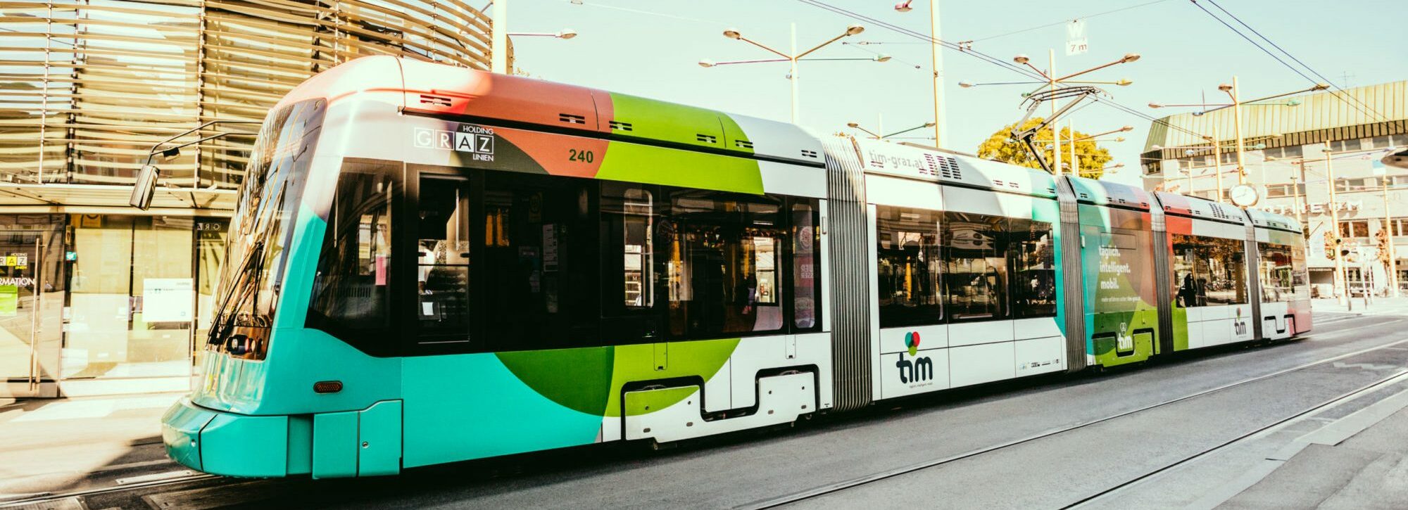 A tram in tim design stands in front of the rondeau at Jakominiplatz