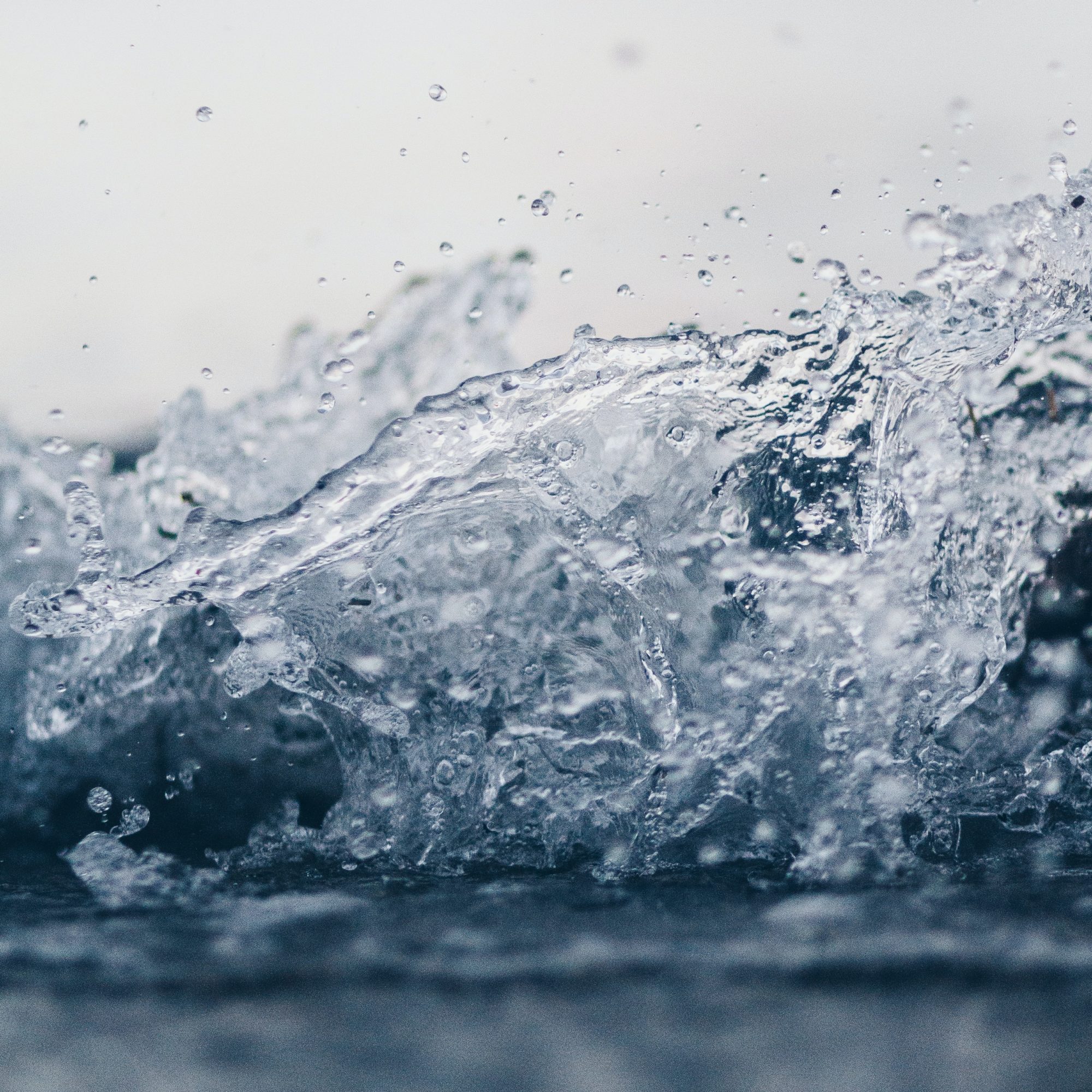 A close-up of water splashing in a pool, creating a crown of droplets.