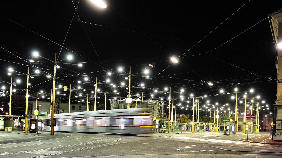 Straßenbahn fährt nachts über den leeren und beleuchteten Jakominiplatz