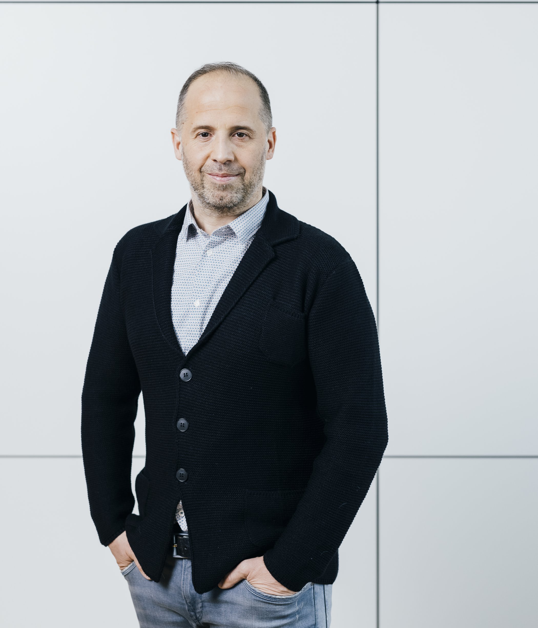A headshot of Gerald Zaczek-Pichler, smiling and wearing a black blazer over a patterned shirt.