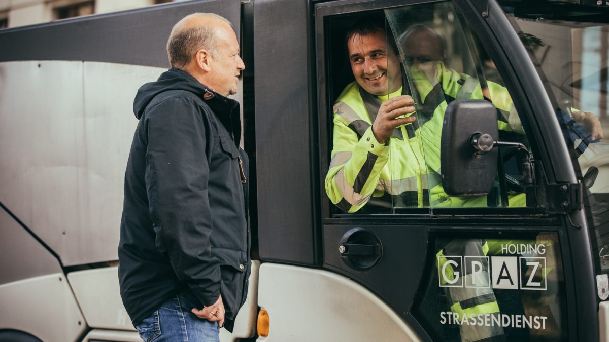 Omputzmann Thomas Hofer unterhält sich mit Fahrer eines kleinen Mülltransporters der Holding Graz.
