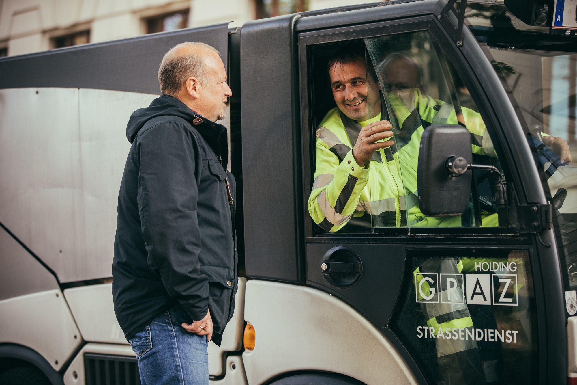 Omputzmann Thomas Hofer unterhält sich mit Fahrer eines kleinen Mülltransporters der Holding Graz.