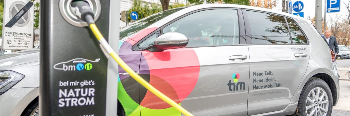 E-Auto am tim-Standort Eisernes Tor hängt an Ladesäule und wird geladen