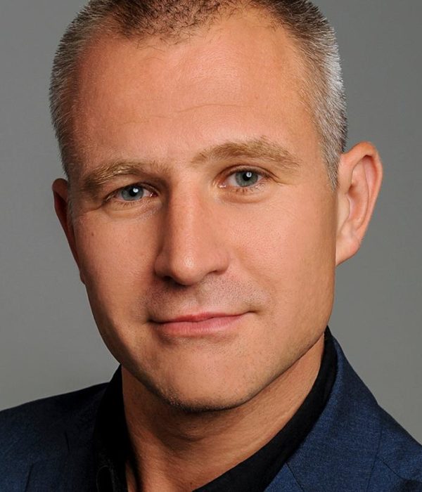 Head and shoulders portrait of Robert Haslinger. He is wearing a blue blazer and looking at the camera.