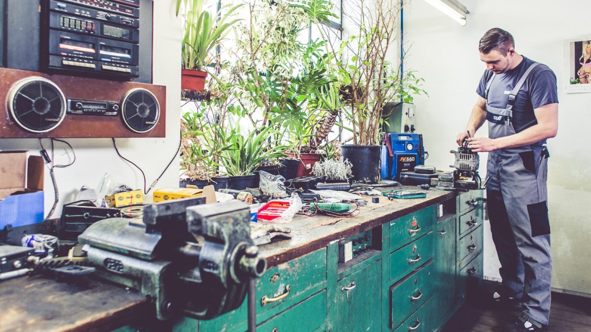 Employee of the municipal workshop repairing an engine part