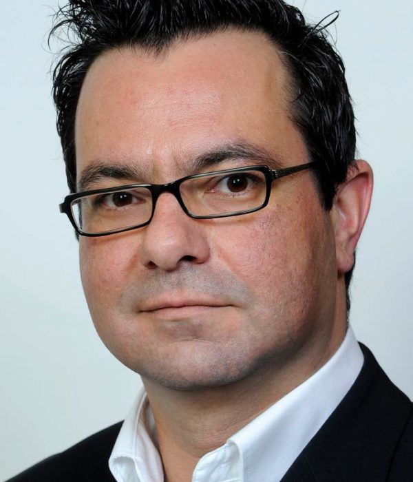 Headshot of Burkhard Steurer wearing a suit and glasses.