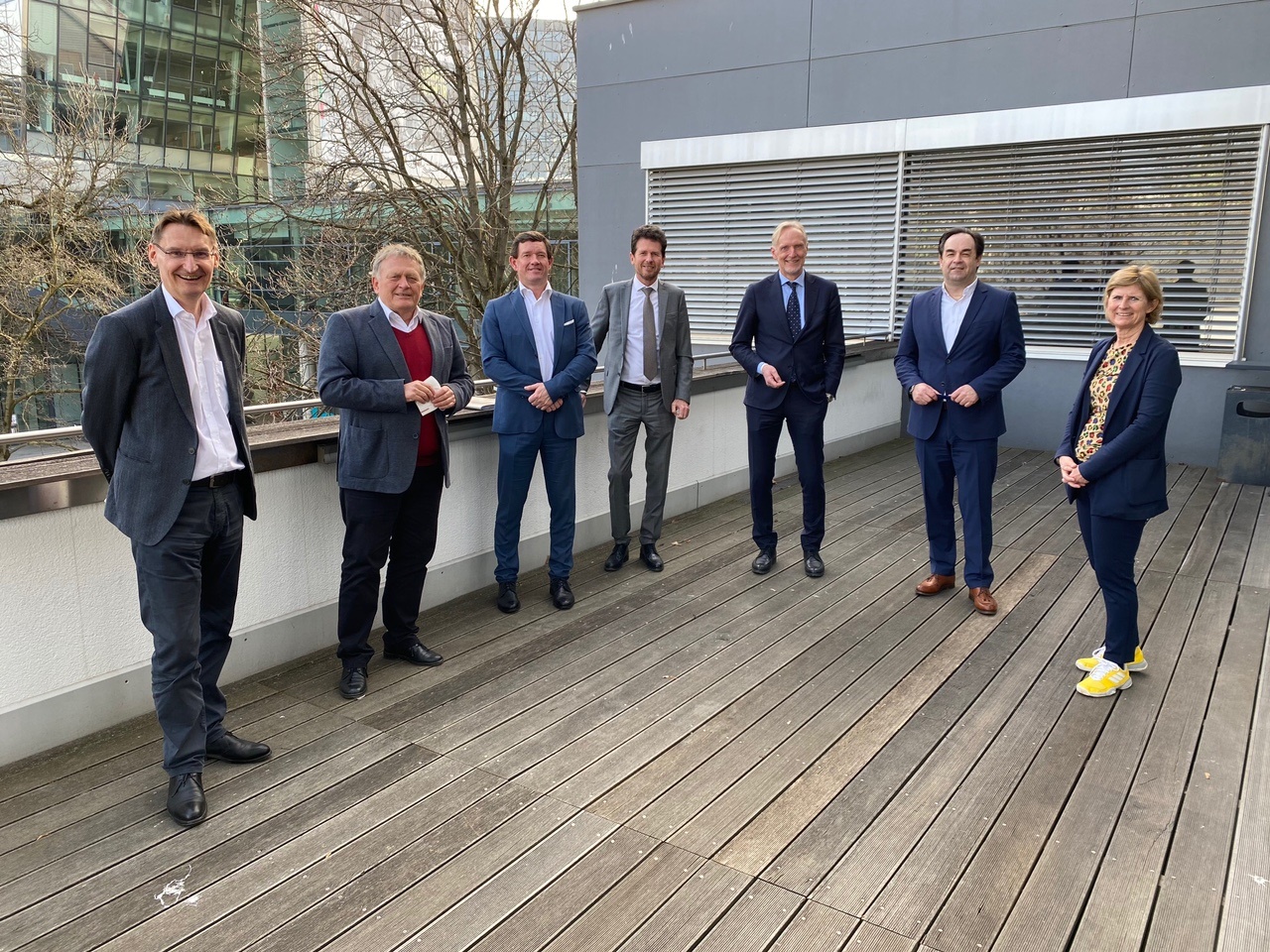 Seven people, including Graz Airport managing directors Wolfgang Grimus and Jürgen Löschnig, stand on a wooden deck.