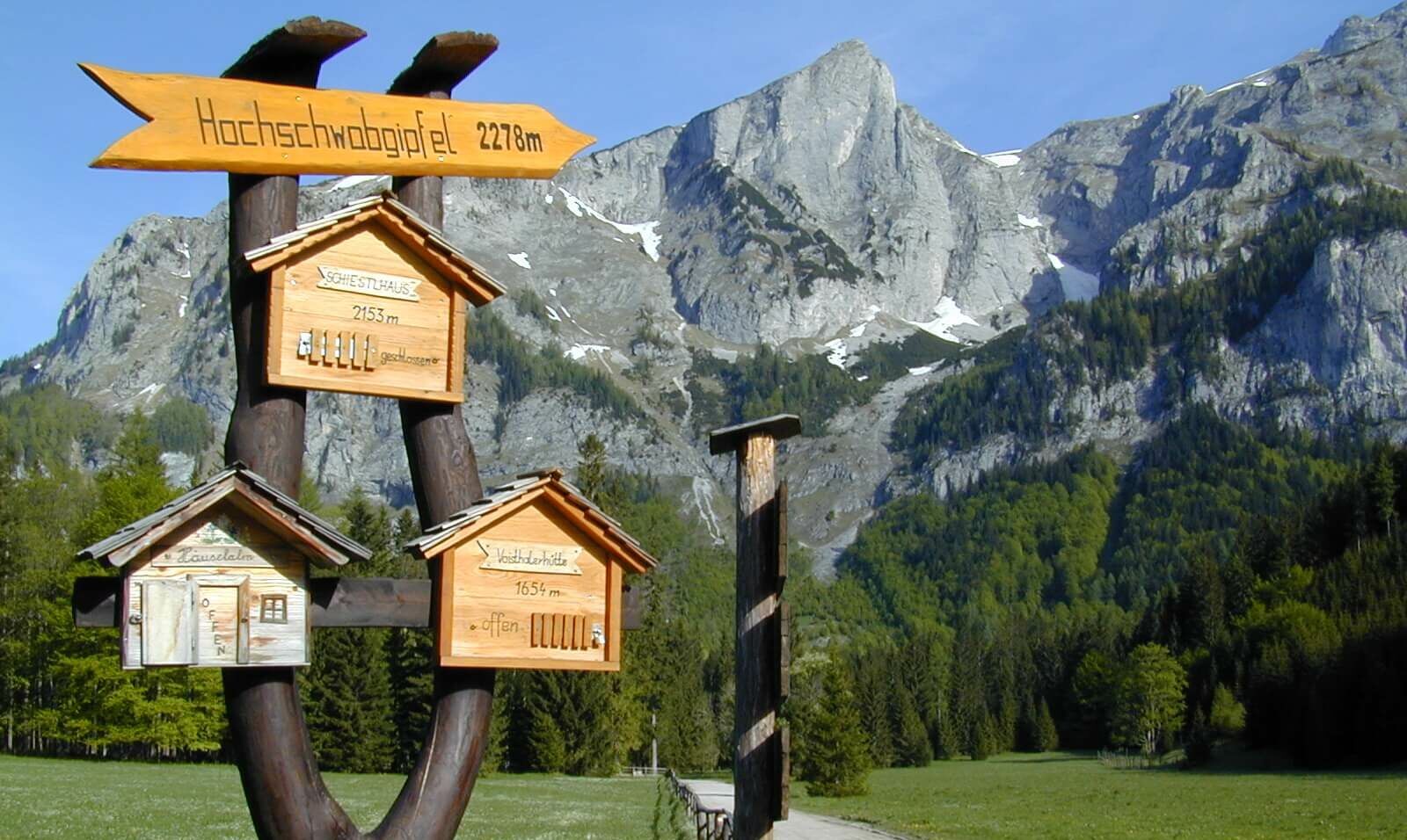 Wegweiser für Wanderer nahe des Alpengasthofes Bodenbauer, im Hintergrund das Hochschwabmassiv