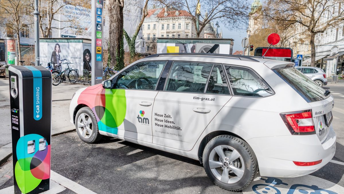 tim-Fahrzeug und tim-Ladesäule am tim-Standort Eisernes Tor, dahinter Blick in Herrengasse
