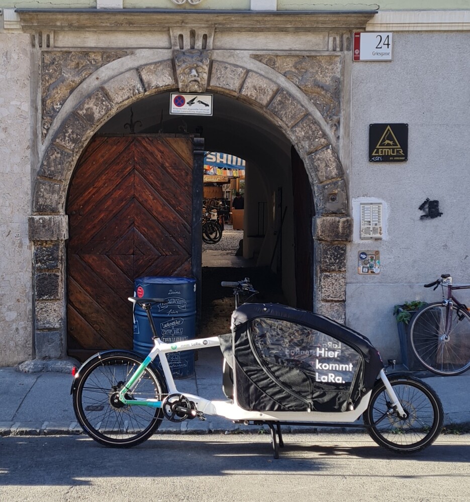 Lastenrad mit dem Schriftzug "Hier kommt LaRa" vor einem Torbogen.