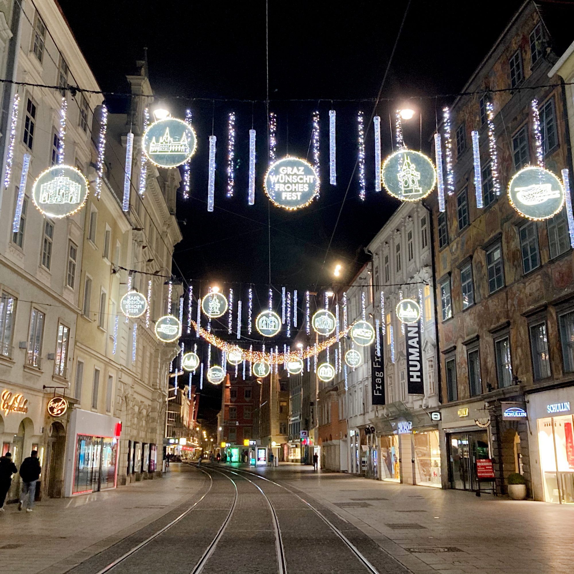 Beleuchtete Straßenbahntrasse in der Herrengasse mit festlicher Weihnachtsdekoration bei Nacht.