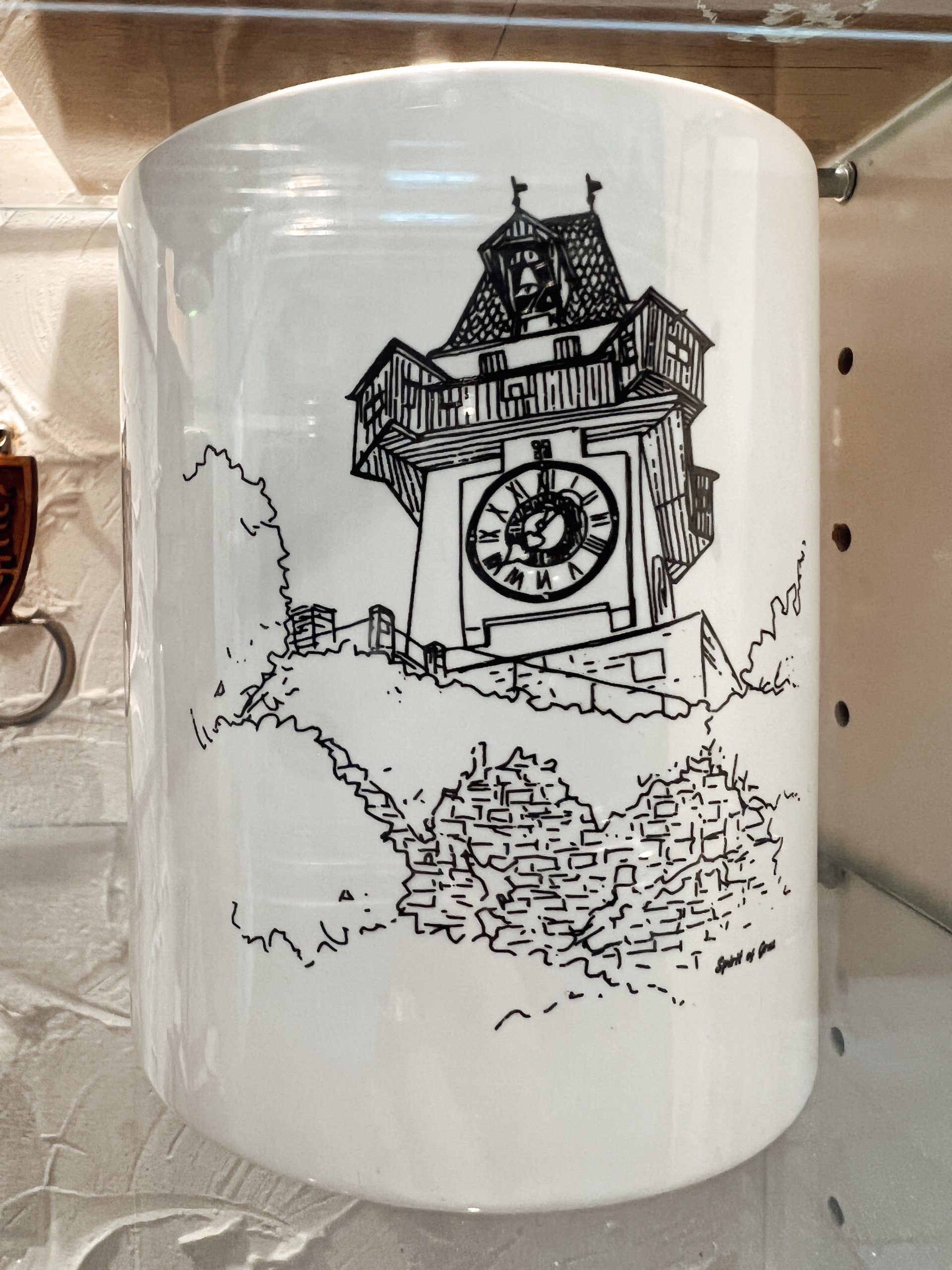 weiße Tasse mit gezeichnetem Uhrturm in schwarz