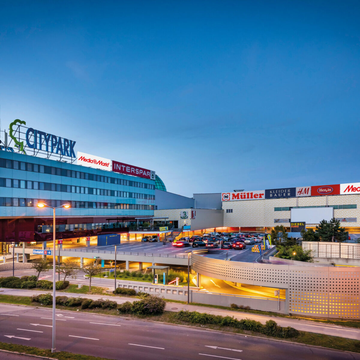 Abendliche Außenansicht des Einkaufszentrums Citypark mit Straße im Vordergrund