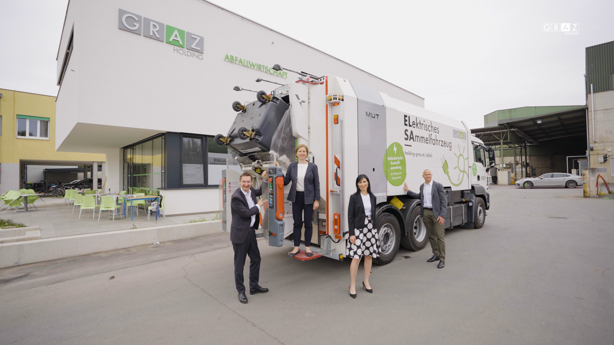 Vorstellung eines elektrischen Sammelfahrzeugs vor der Grazer Abfallwirtschaft mit vier Personen.