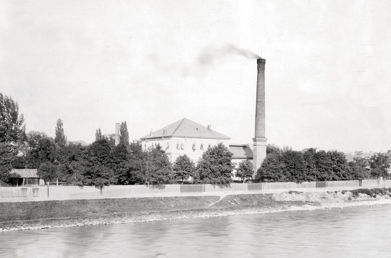 Wasserwerk Körösistraße um 1980, Schwarzweißbild des Gebäudes mit Schornstein nahe Mur