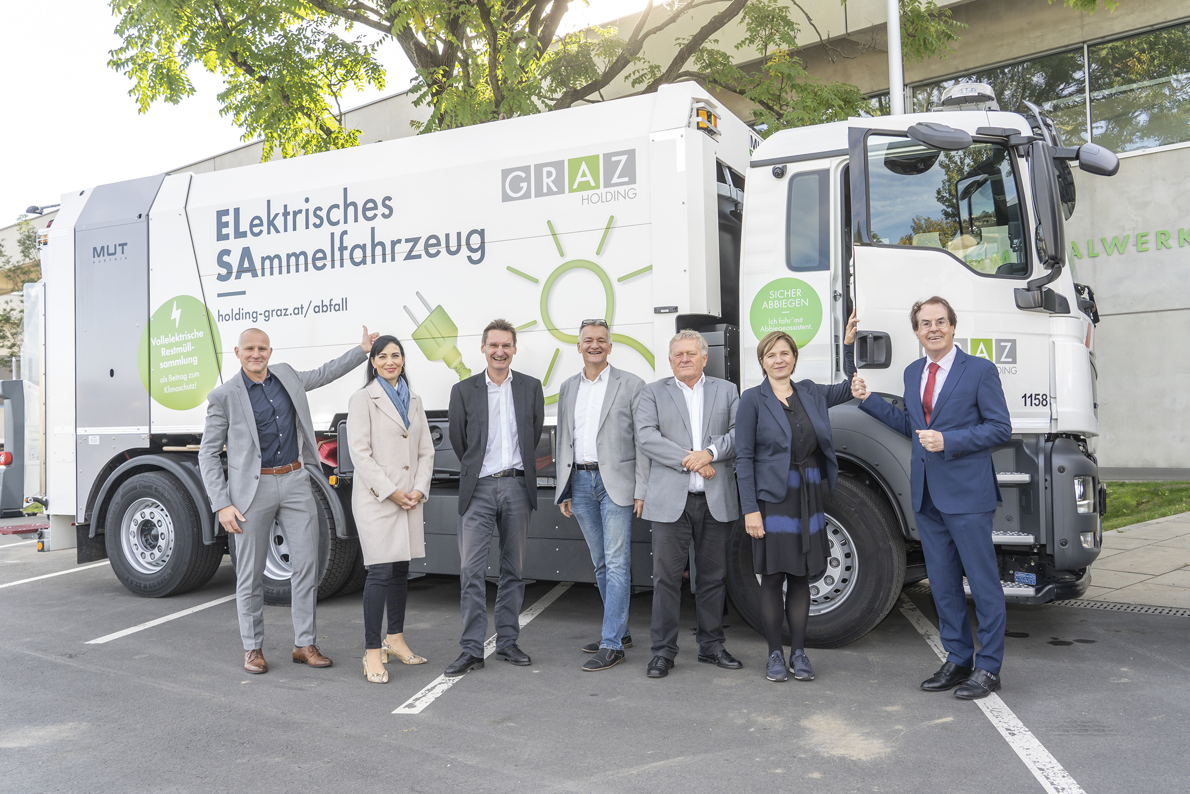 Gruppenfoto vor elektrischem Sammelfahrzeug der Graz Holding zur Förderung der Elektromobilität.