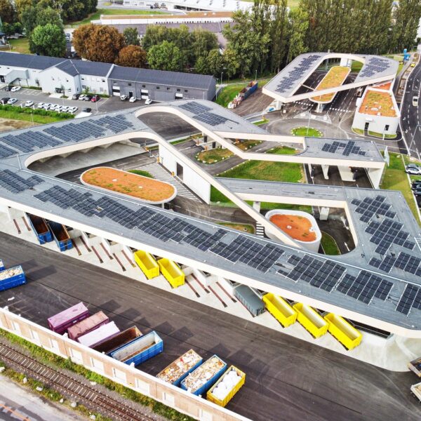 Aerial view of the Graz Resource Park, featuring a large building with solar panels and a recycling center.