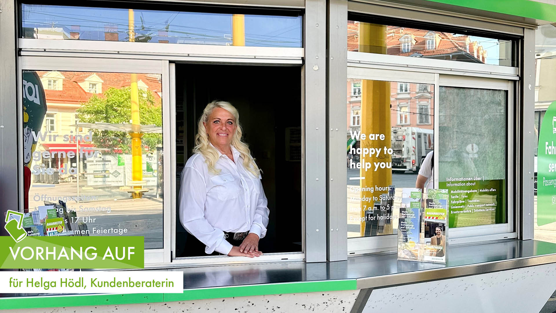Kundenberaterin Helga Hödl lächelnd am Fahrgastservice-Schalter in Graz mit Informationsmaterial.