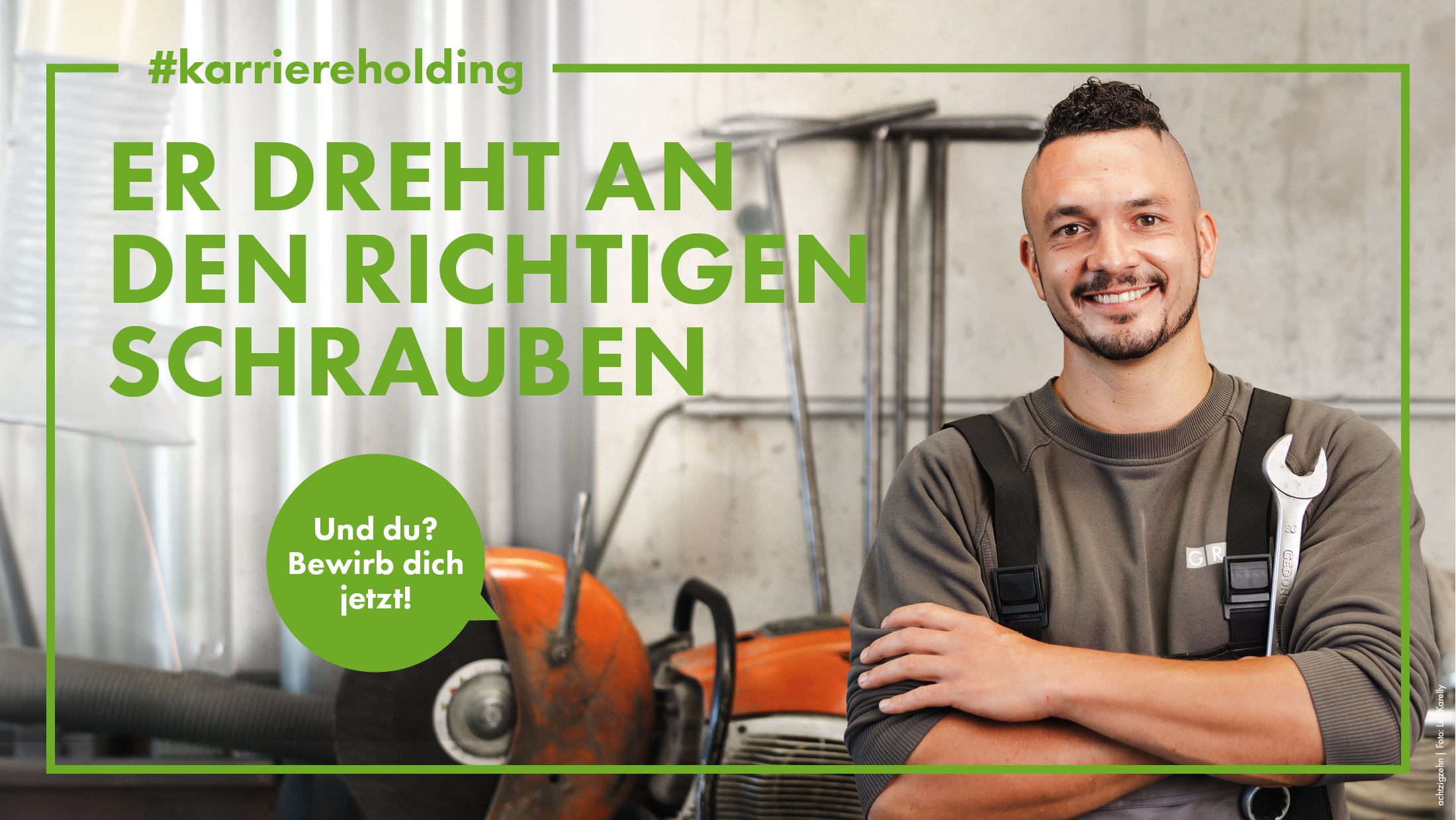 Lächelnder Mann in Arbeitskleidung mit Schraubenschlüssel in Werkstatt. Text: „Er dreht an den richtigen Schrauben“