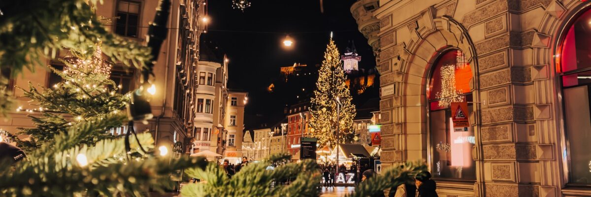 Beleuchteter Weihnachtsbaum auf dem Grazer Hauptplatz mit Blick auf den Uhrturm.