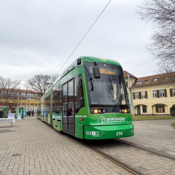 Green Graz tram with "100 Jahre" and "Bankkunden" displayed. Tram number 236.