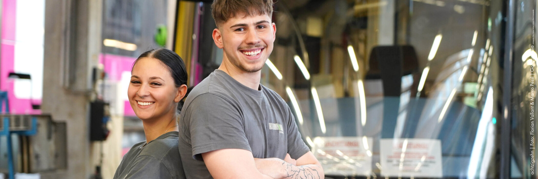 Männlicher und weiblicher Lehrling in Arbeitsmontur und mit Bohrern in den Händen in der Werkstätte der Graz Linien