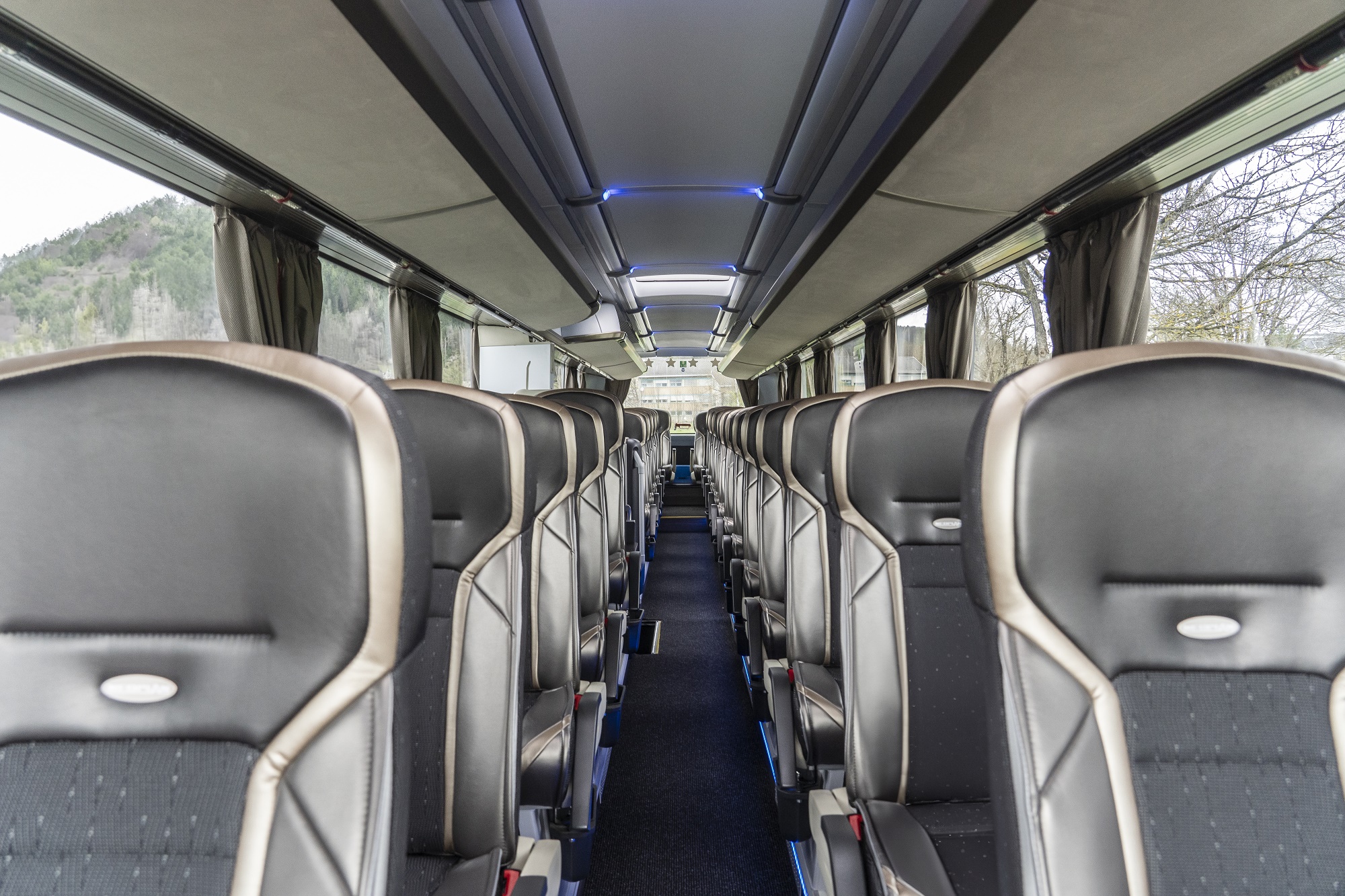 The interior of a Graz Linien bus with rows of black and gray seats.