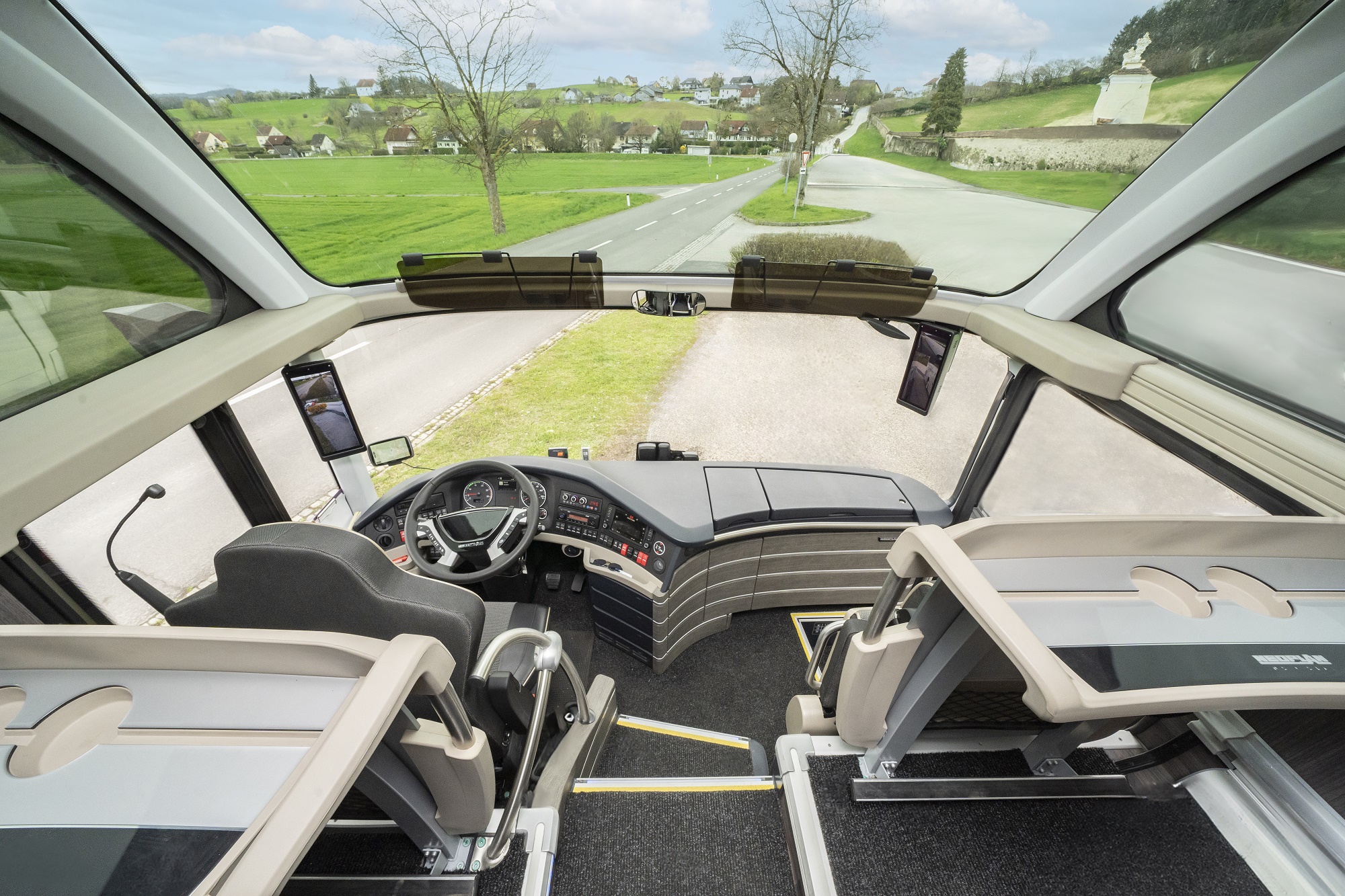 Blick aus dem Fahrerstand eines Reisebusses der Graz Linien auf eine Landstraße.