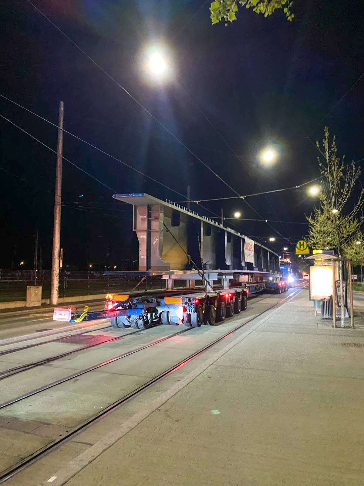Ein LKW transportiert nachts einen Teil der Tegetthoffbrücke über Gleise in Graz.