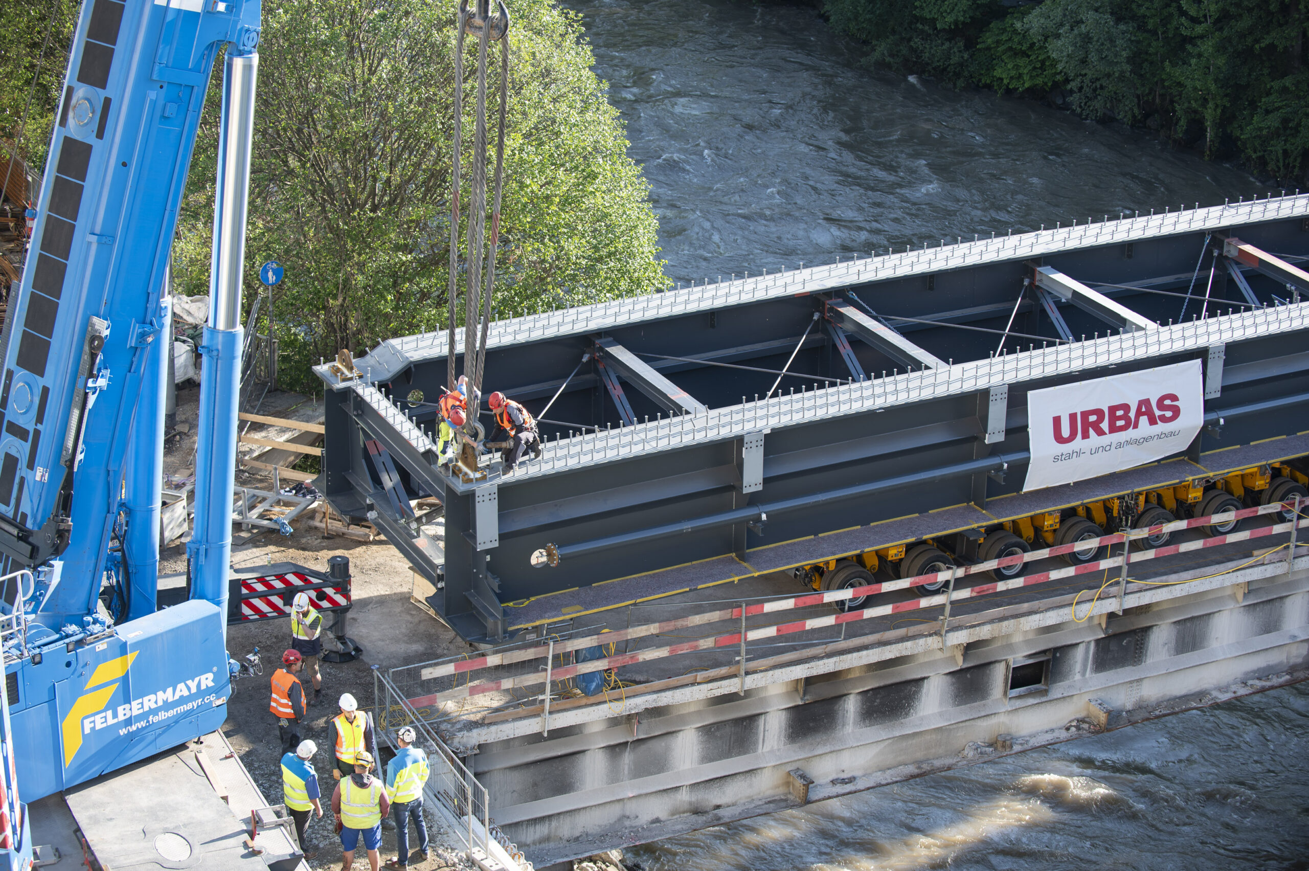 Ein Kran hebt ein Brückenteil auf die über die Mur führende Tegetthoffbrücke.