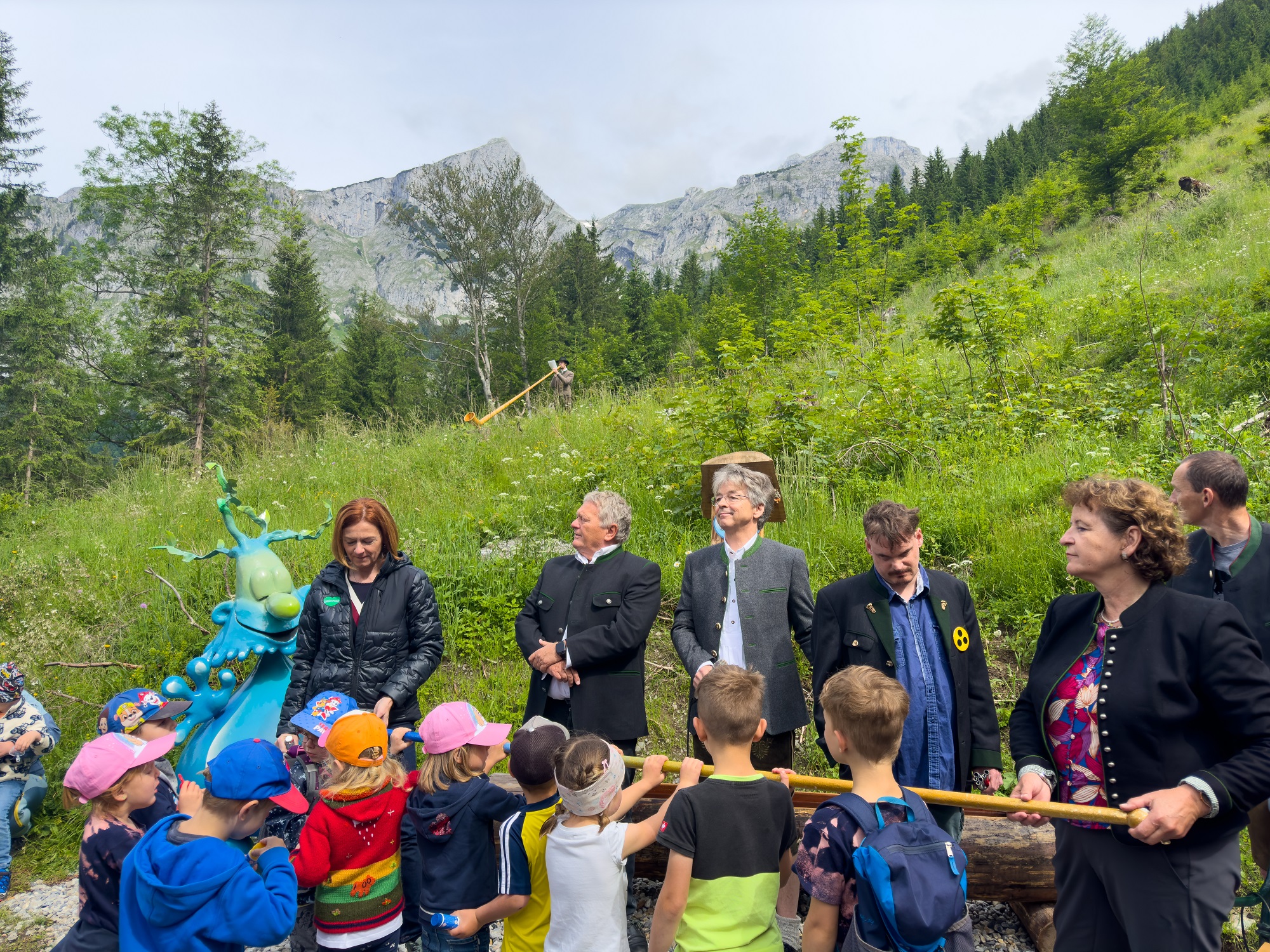 Gruppenfoto vom Trinkwassertag 2024 mit Erwachsenen und Kindern vor einer Bergkulisse.