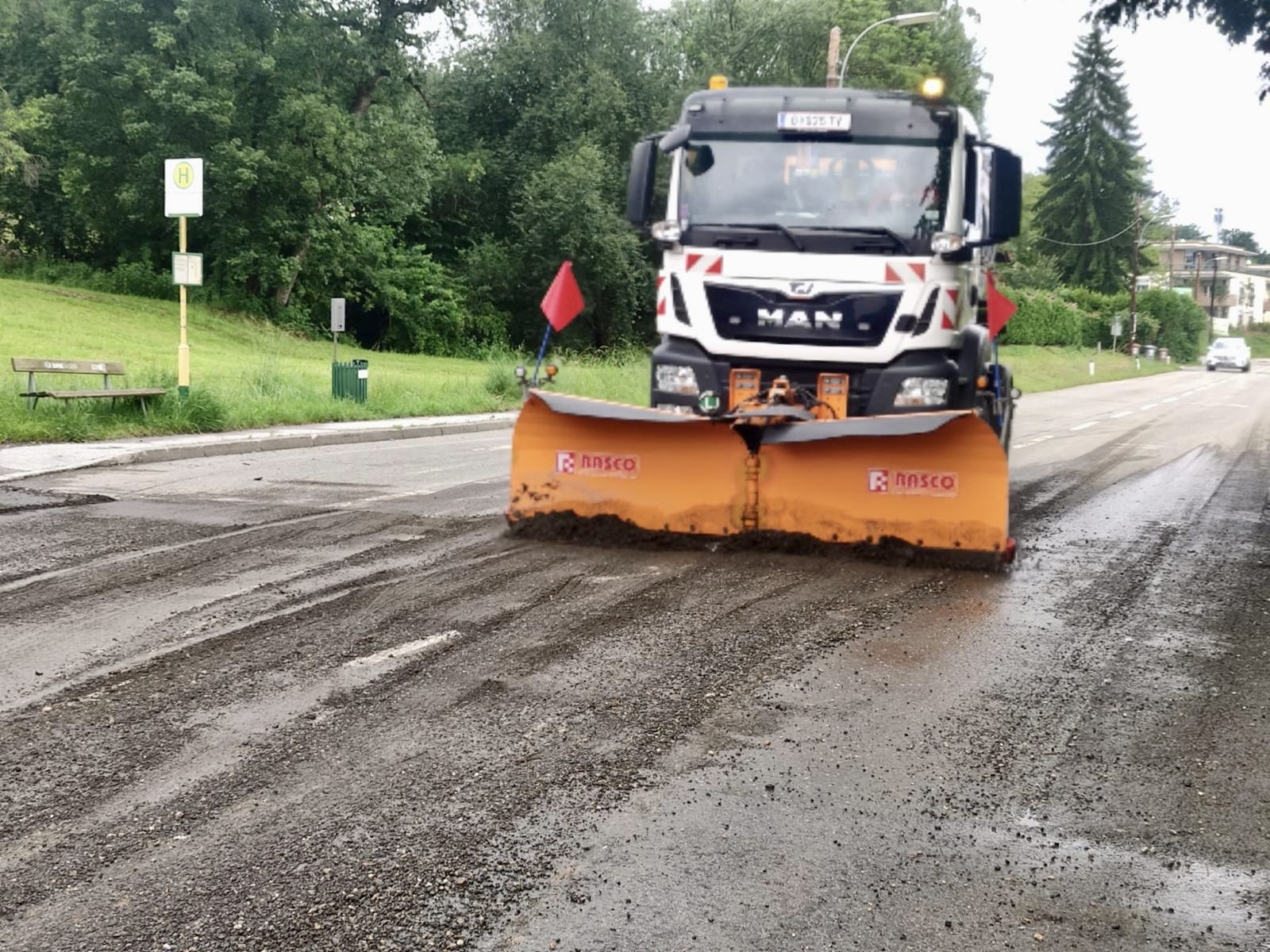 Ein MAN LKW mit Schneepflug räumt eine Strasse nach einem Unwetter auf.