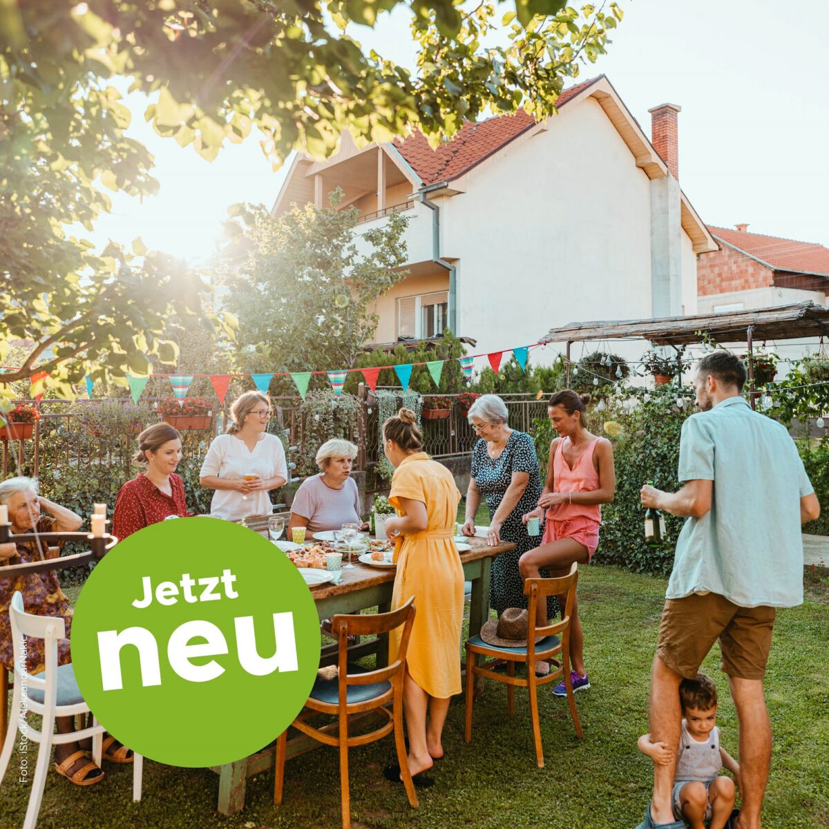 Gruppe Menschen feiert im Garten mit Tisch voller Essen und Getränke. "Jetzt neu" steht auf Bild.