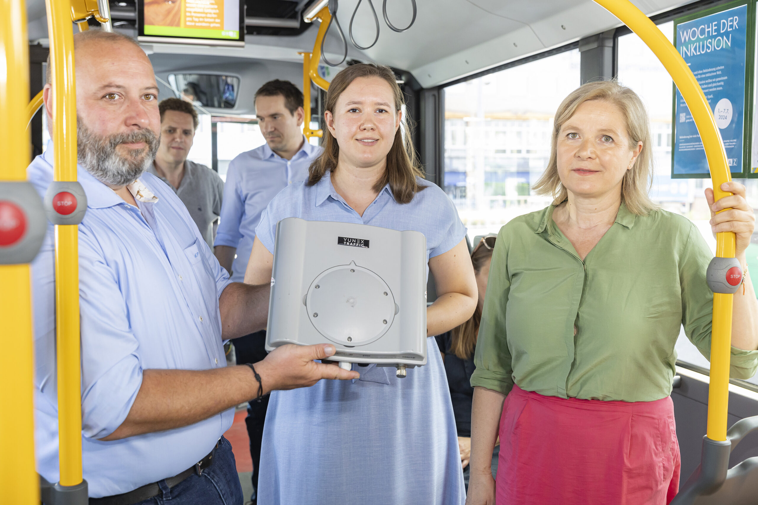 Mark Perz, Elisabeth Burghard und Judith Schwentner mit "Yunex Traffic"-Box in Bus in Graz.