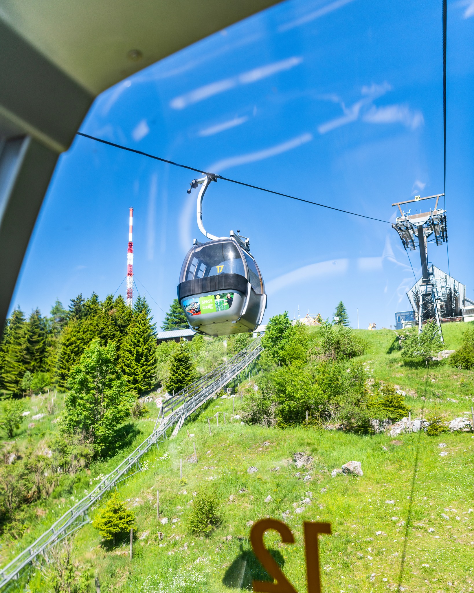 Blick aus der Schöckl Seilbahn auf die Berglandschaft, dahinter Sendemast am Schöckl-Plateau.