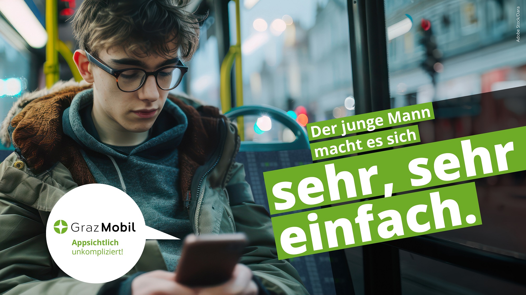 Junger Mann sitzt in Bus und benutzt Smartphone. Text: "Graz Mobil: Appsichtlich unkompliziert!"