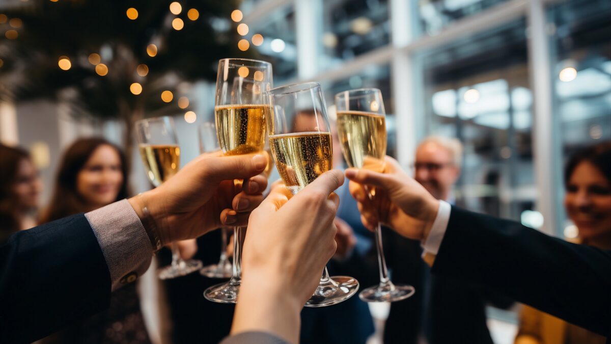 Mehrere Hände stoßen mit Sektgläsern an.