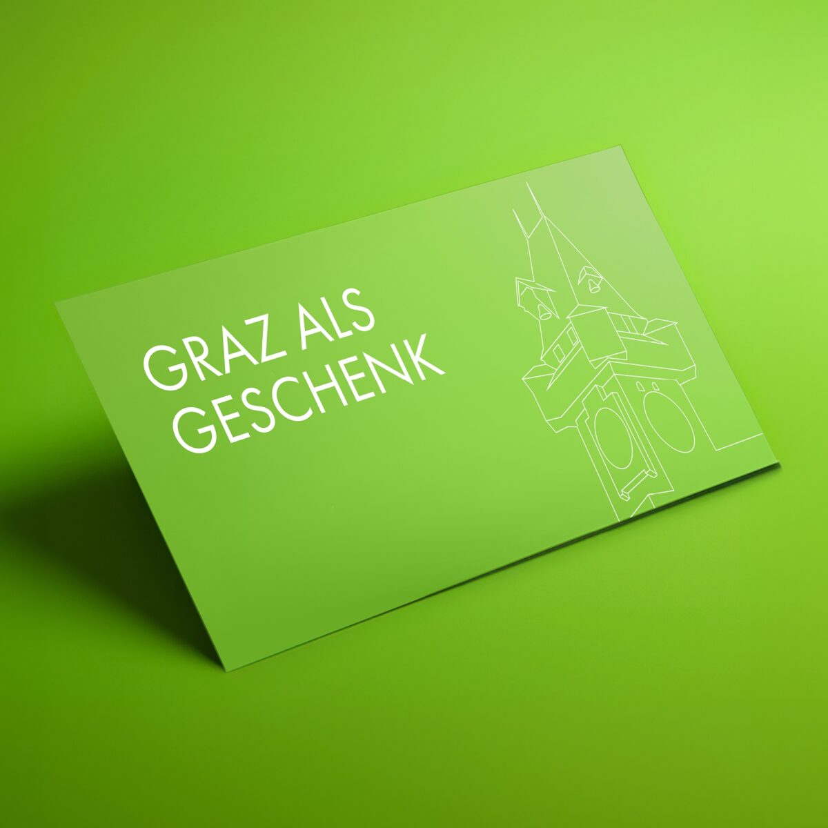 Grüne Karte mit Aufschrift "Graz als Geschenk" und Grafik des Grazer Uhrturms.