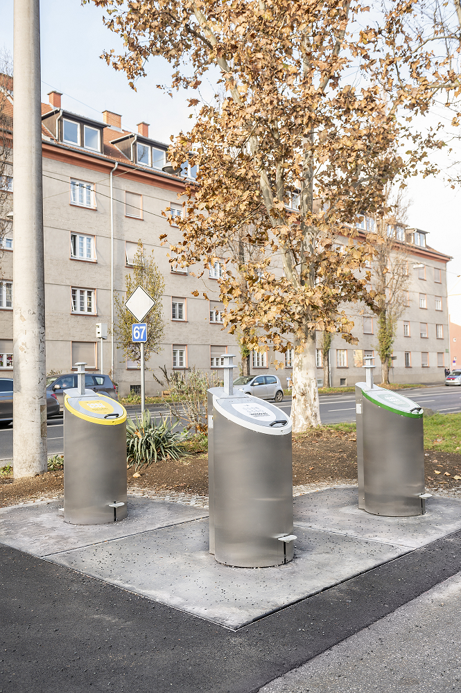 Drei unterirdische Müllcontainer (gelb, weiß, grün) auf der Tändelwiese in Graz.