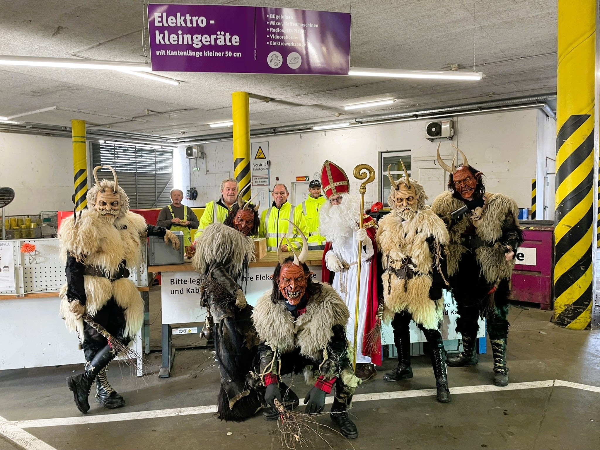 Krampusse und ein Nikolo mit Mitarbeiter:innen des Ressourcenpark Graz