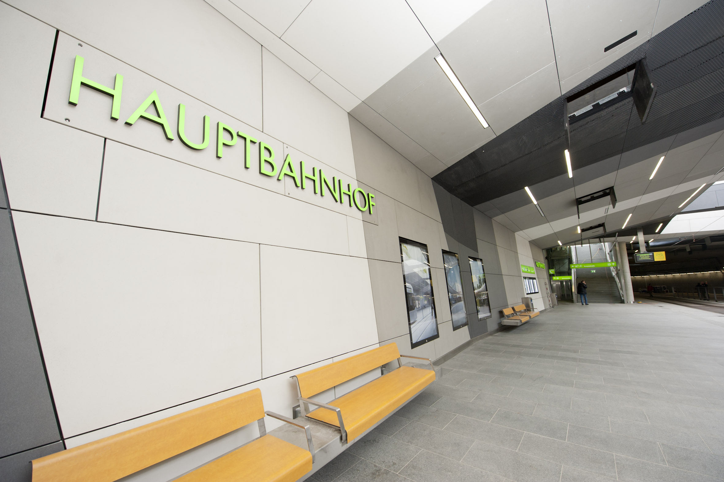 Eingangsbereich der Nahverkehrsdrehscheibe Hauptbahnhof mit Bänken und Hinweisschildern.