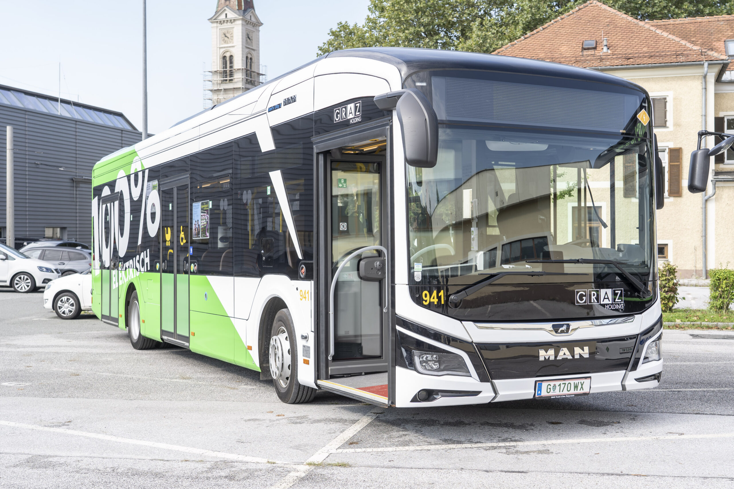 Weißer Elektrobus der Graz Linien mit Aufschrift "100% elektrisch" steht auf Parkplatz.