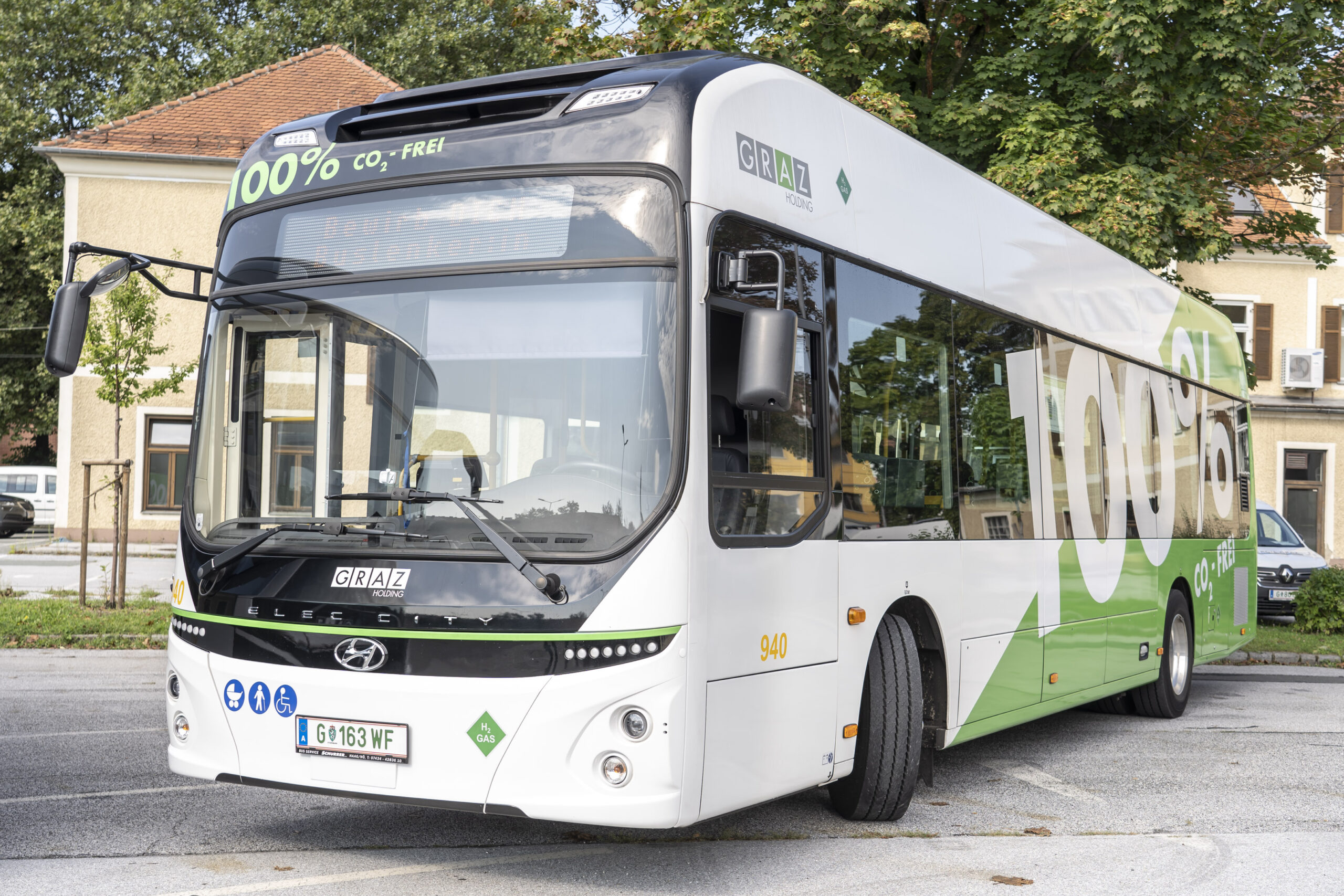 Ein weißer Wasserstoffbus der Graz Linien mit der Aufschrift "100% CO₂-frei" auf einem Parkplatz.