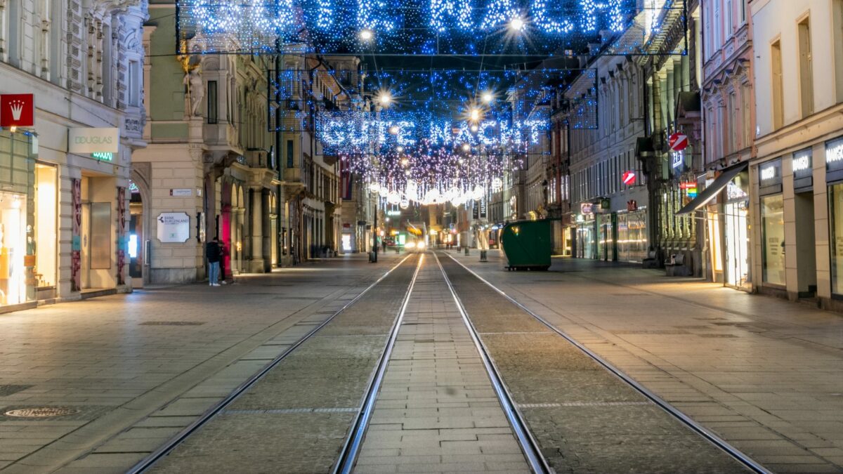 Leere Heerengasse mit Straßenbahngleisen und festlicher Beleuchtung, Schriftzug „Gute Nacht“.