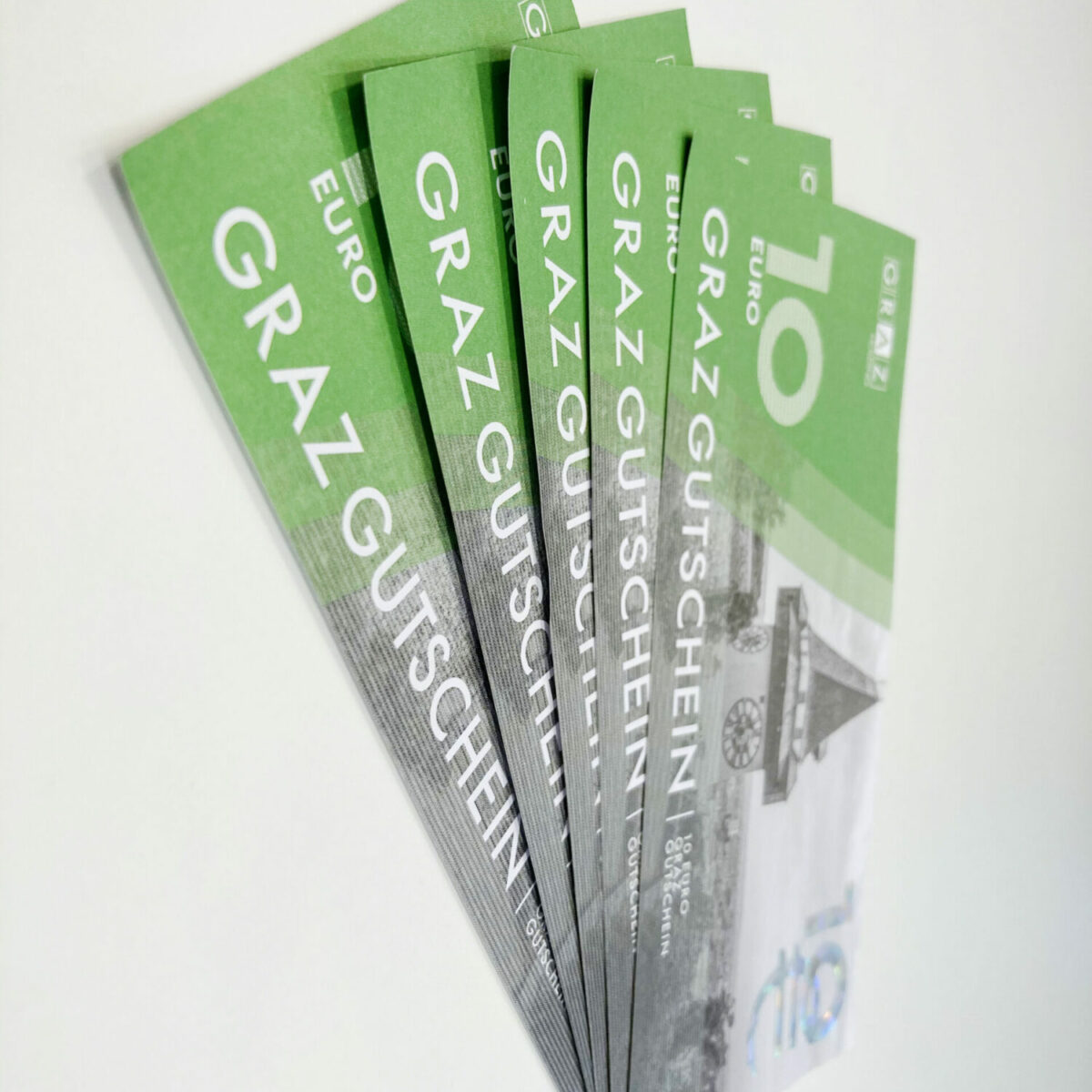Fächer von Graz-Gutscheinen im Wert von 10 Euro, auf weißem Hintergrund arrangiert.