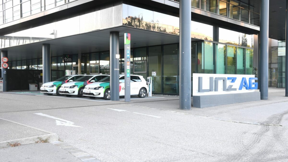 Drei tim-Fahrzeuge am tim Linz-Standort bei der Linz AG, daneben Firmenlogo der Linz AG