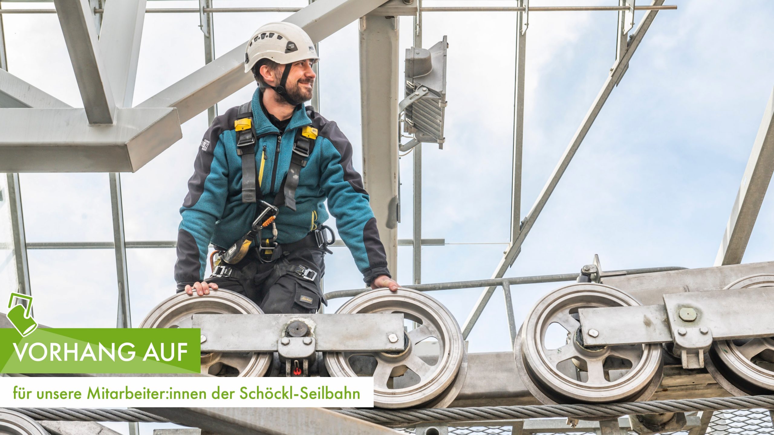 Ein Mitarbeiter mit Helm arbeitet an der Schöckl-Seilbahn auf einer Stahlkonstruktion.