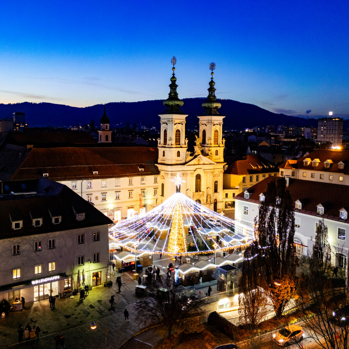 Blick auf den Grazer Hauptplatz mit Lichterketten und der Franziskanerkirche.